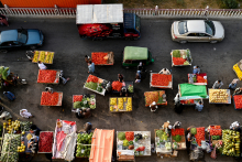 Des hommes afghans achètent des légumes et des fruits sur un marché le long d'une route à Mazar-i-Sharif le 21 juin 2025. Wakil KOHSAR / AFP